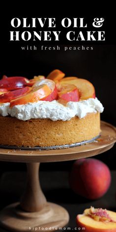 a cake with fresh peaches on top and the words olive oil & honey cake above it