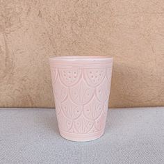 a pink cup sitting on top of a table