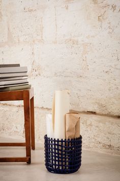 a basket that has some books in it next to a table with a book on it