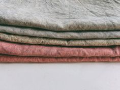 four different colored linens stacked on top of each other