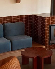 a living room filled with furniture and a wood burning stove in the middle of it