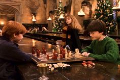 two young boys playing chess in a bar with christmas decorations on the wall behind them