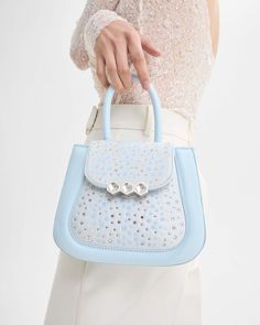 The Mini Jill bag, inspired by the 70s, is a structured bag with soft and padded cowhide leather, applying the contemporary touch of Mietis with the detail of the hand-painted edges and stitching in contrasting colors. Made with Swarovski crystals, this limited edition gem is a must-have for those seeking a touch of luxury coupled with originality. The crystals, reminiscent of rippling waves, blend shades of blue and silver for a subtle yet striking effect. Finished with a custom metallic closur Luxury Couple, Structured Bag, The 70s, Painting Edges, Card Holder Wallet, Accessories Shop, Cowhide Leather, Blue And Silver, Shades Of Blue