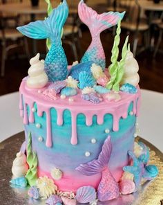 there is a cake decorated with mermaids and seashells