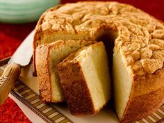 a cake that has been cut into pieces on a plate with a knife next to it