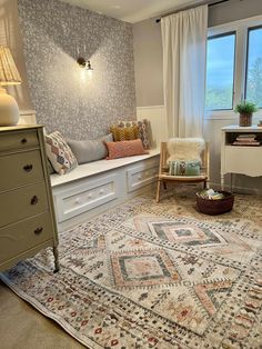 a living room with a large rug on the floor next to a chair and window