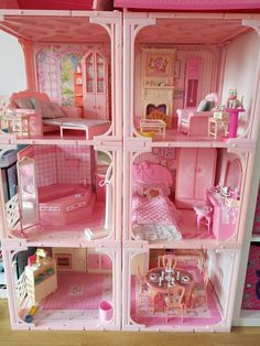 a pink doll house with furniture and accessories