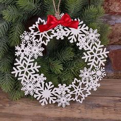 an ornament hanging from a christmas tree with snowflakes and a red bow