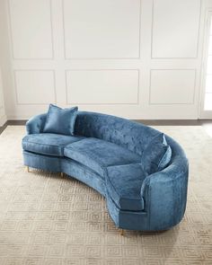 a large blue couch sitting on top of a carpeted floor next to a white wall