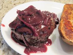 a piece of bread with chocolate sauce on it next to some type of meatloaf