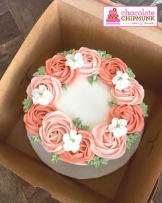 a cake in a box decorated with pink and white flowers