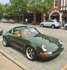 a green sports car is parked on the side of the road