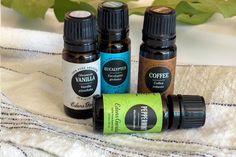 three bottles of essential oils sitting on a towel