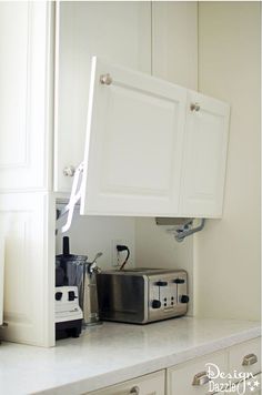 a kitchen with white cabinets and appliances on the counter