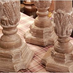 three stone pedestals sitting on top of a checkered table cloth covered tablecloth