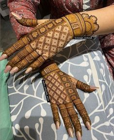 two hands with henna tattoos on them