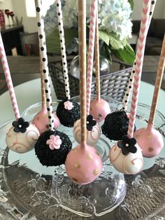 there are some cake pops with black and pink decorations on them