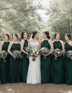 a group of women standing next to each other wearing green dresses and holding bouquets