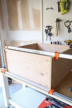 a workbench with tools on the wall and pegs hanging from it's sides