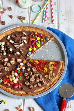 a chocolate cake with many different toppings on it and some spoons next to it