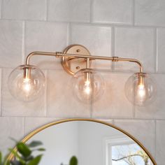 a bathroom light with three lights on it and a mirror in front of the wall