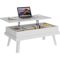 a coffee table with a laptop on it and drawers underneath the top that is open