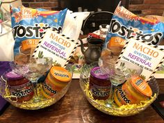 two bowls filled with food sitting on top of a table next to bags of chips