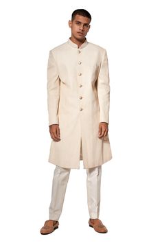 Ivory sherwani with pin tucks detail and front button placket. Paired with pant.
Components:2

Neckline:Mandarin
Sleeve Length:Full
Fabric:Cotton Silk
Color:White
Front button placket - Aza Fashions Classic Fitted Sherwani With Naqshi Detailing, Classic Sherwani With Naqshi For Wedding, Classic Cream Bandhgala For Festive Occasions, Classic Cream Sherwani For Festive Occasions, Designer Cream Kurta For Formal Occasions, Classic Long Sleeve Sherwani With Naqshi, Designer Beige Sherwani For Formal Occasions, Classic Fitted Naqshi Kurta, Classic Dabka Sherwani For Eid