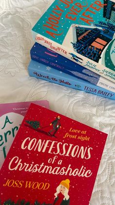 four books sitting on top of a bed next to each other in front of a white bedspread