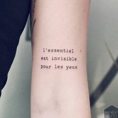 a person with a tattoo on their arm that reads i essentiel est invisible pour les yeux