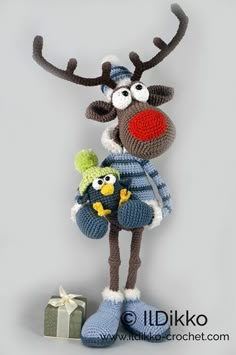 a crocheted reindeer holding a small stuffed animal