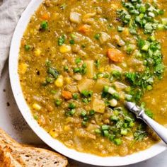 a white bowl filled with soup next to bread