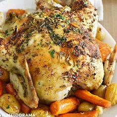 a white plate topped with chicken, carrots and potatoes