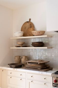 the shelves in the kitchen are filled with dishes and bowls on top of each other