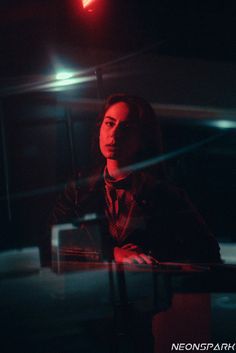 a woman sitting at a table in the dark with a red light on her head