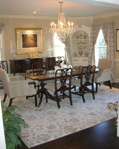 a formal dining room with chandelier, chairs, and table in the center