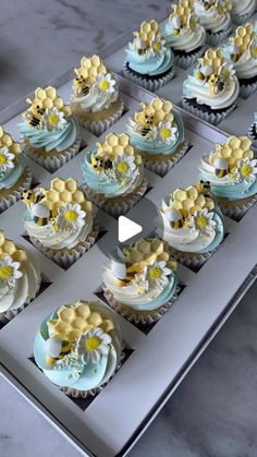 the cupcakes are decorated with yellow and blue frosting on top of each other