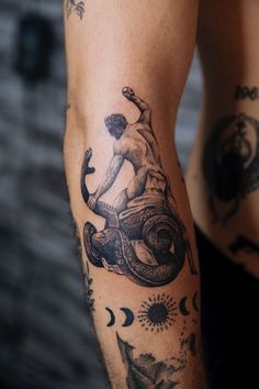 a man's arm with tattoos on it and an octopus in the middle of his arm