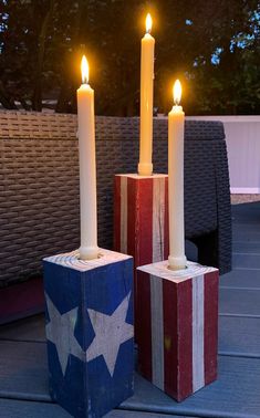 two candles are sitting on blocks with the colors of the american flag