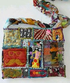 a multicolored patchwork purse is hanging on the wall