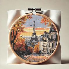 a cross - stitch picture of the eiffel tower in paris is displayed on a pillow