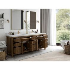 a bathroom with two sinks, mirrors and pictures on the wall next to a bathtub