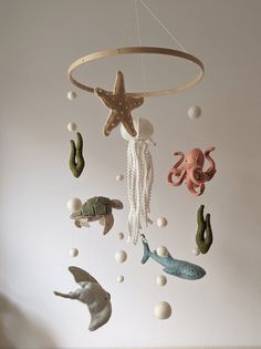 an octopus, starfish, and seahorse mobile hanging from a ceiling in a white room