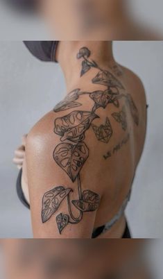 the back of a woman's shoulder with tattoos on her arm and chest,