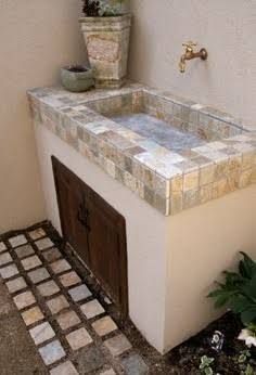 a bathroom sink sitting under a window next to a potted plant