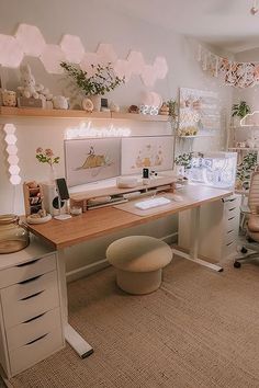 a home office with white furniture and lots of plants on the wall above the desk