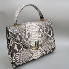 Finished in a gorgeous serpentine pattern, this elegant women's handbag adds a touch of glamour to your attire. Crafted from genuine leather, this exotic purse is fitted with a single handle that gives it a chic look. Designed with spacious interiors, it can hold all your necessities and even has additional pockets on the inside for the smaller articles. Equipped with a cover closure, order this fabulous handbag soon!

Specifications




Types of bags: Handbags & Crossbody bags

Style: Fashion Elegant Leather Satchel With Single Handle, Luxury Snake Print Shoulder Bag, Elegant Crocodile Pattern Clutch Shoulder Bag, Elegant Clutch Shoulder Bag With Crocodile Pattern, Elegant Double Handle Fashion Satchel, Luxury Leather Snake Print Shoulder Bag, Luxury Leather Shoulder Bag With Snake Print, Elegant Single Handle Satchel For Evening, Elegant Crocodile Pattern Bags