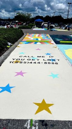 the sidewalk has stars painted on it and words written in white, blue, yellow and pink