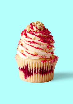 a cupcake with white frosting and red sprinkles