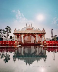 an ornate gazebo sits in the middle of a lake